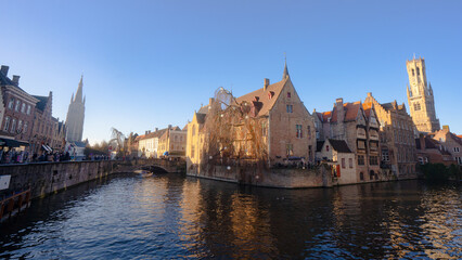 Rozenhoedkaai in Brugge , panoramic view along the canal and medieval buildings in old town during  winter sunny day : Brugge , Belgium : November 30 , 2019