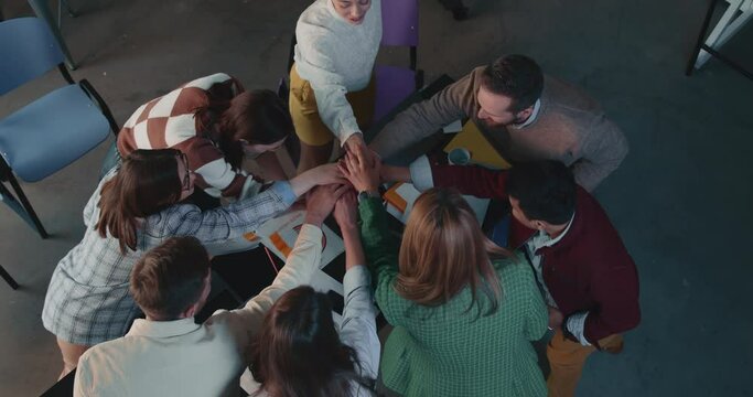 Team spirit concept. Top view group of business people join hands, applaud and high five at office meeting slow motion.