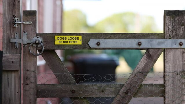 Gate with dogs loose do not enter sign