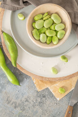 Fresh and raw green broad beans on kitchen table.