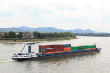 Container ship on river Rhine (Rhein) in Bonn, Germany - obrazy, fototapety, plakaty