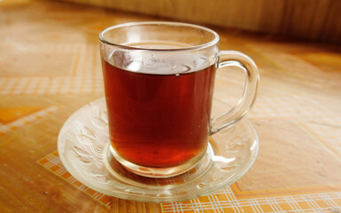 Tea in white glass on wooden table background