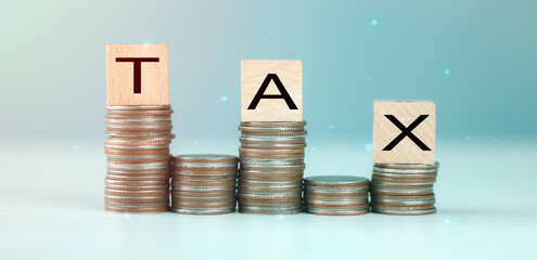 Wooden cubes with the word Tax on a pile of coins, Tax income tax return form online for tax payment Government, state taxes, Data analysis, financial research, report Calculation tax return