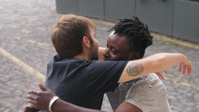 Two diverse friends hugging outside. Young multi-racial friends embrace