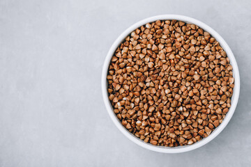 Buckwheat. Organic raw dry Buckwheat grains in bowl on gray stone background.