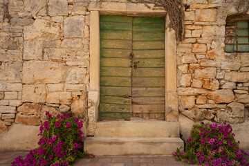 Fototapeta na wymiar Old wooden door in a stone wall 