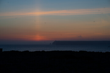 mystical sunset by the sea with a section of coast	