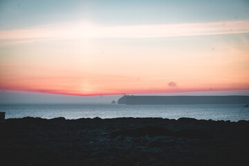 mystical sunset by the sea with a section of coast	