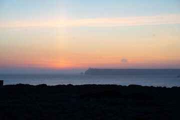 mystical sunset by the sea with a section of coast	