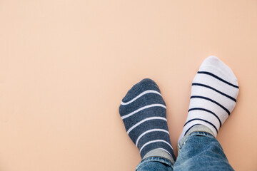 Odd socks day concept. Legs in different socks on a blue background. Top view.