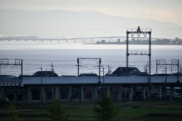 Fototapeta na wymiar 夕暮れの湖西線。琵琶湖と琵琶湖大橋