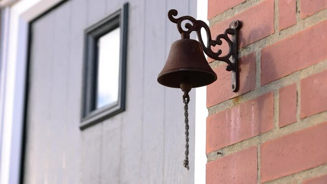 Old rusty door bell, string blowing in the wind