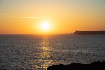 mystical sunset by the sea with a section of coast
