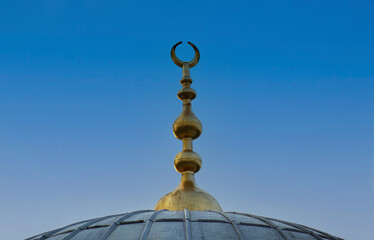 mosque dome and golden alem isolated on clean blue sky