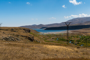 Mountain landscape with a lake about power pylons in Armenia.