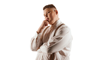 Portrait of teen boy, overweight model in white shirt and suspenders isolated over white studio...