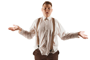 Frustration, resentment. Overweight boy in white shirt and suspenders isolated over white studio...
