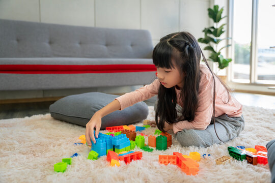 Asian girl pictures Playing block puzzle games at home together having fun and happiness.