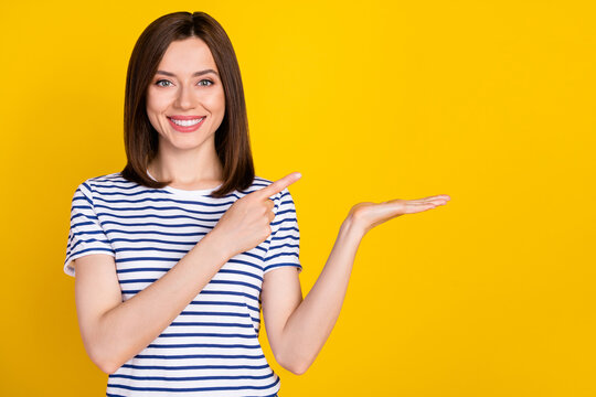 Photo of young attractive pretty cute woman directing finger hold hand object recommend buy cheap isolated on yellow color background