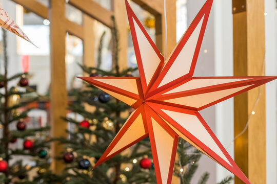 A Christmas star in the window. Warm light, Christmas, cosy atmosphere. Advent time.Paper lightning lantern in star form. new year decoration