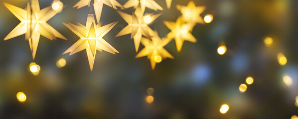 shiny christmas stars decoration on abstract background with blurred lights, illumination for...