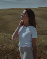 Young female model in Tuscany, Italy. Beautiful woman and green tuscan hills in the background and tuscan landscape