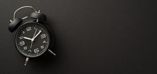 Black friday shopping concept. Top view photo of black alarm clock on isolated black background...