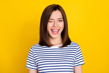Fototapeta premium Photo portrait of nice young woman excited wink toothy smile good mood dressed trendy striped clothes isolated on yellow color background