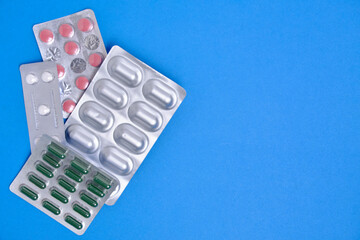 Lot of pills in package blue background. Concept shortage and rise in price medicines.