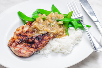 pork steak with onion sauce, green beans and rice