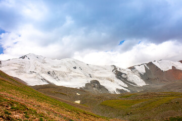 Obraz premium Beautiful nature of rocky mountains and peaks with glaciers. Unusual landscape of nature. Rocks on the background of the sky with clouds. Bad weather cyclone, rainy season, foggy day.