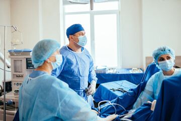 Coordinated work of the medical staff and and male surgeon doctor of surgeons team during operation...