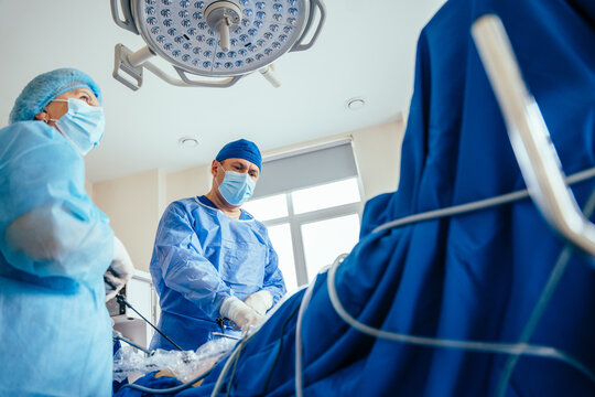 Low angle of experienced surgeon doctors team is working in the operating room. Surgeons in operating room at hospital.