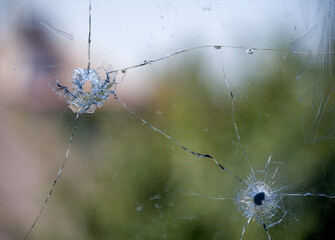 bullet hole in cracked window glass