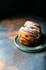 cruffin with raisins in powdered sugar on a green plate festive pastries