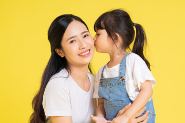 image of asian mother and daughter posing on a yellow background