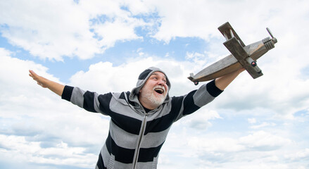 cheerful senior retired man. mature man at retirement. old man on sky background with toy plane