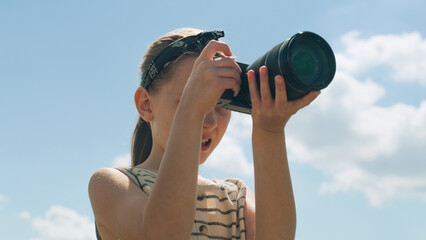 Young photographer shooting landscape. Girl taking pictures of nature, watching result, upgrading...
