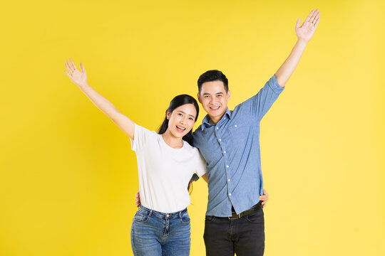 image of asian couple posing on yellow background
