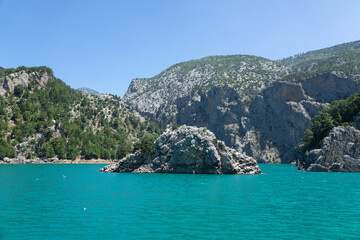 Fototapeta na wymiar View of the lake with clear turquoise water and on the mountain cliffs of the Green Canyon. Landscape of Green canyon, Manavgat, Antalya, Turkey