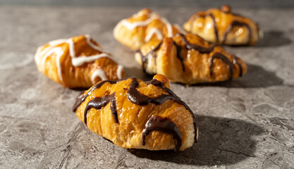 Set of delicious freshly baked croissants with chocolate on top on a background