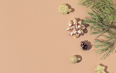 Obraz na płótnie Canvas Winter composition made of fir branches and christmas decoration on pastel beige background. Christmas and new year concept. Flat lay. Top view, copy space.