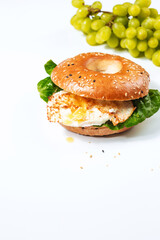 Bagel with sesame and yayoi on a white background. Sandwich with salad and protein with space for text