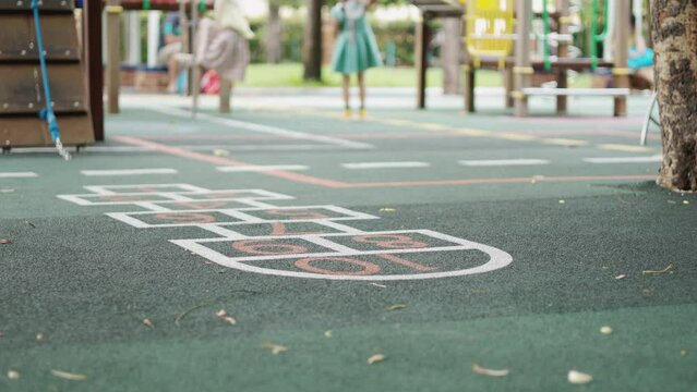Blurred background with copy space of playground floor and seeing kindergarten kids who are playing with their friends at school shows concept of child recreation and activity with enjoyment.