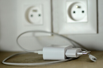 Concept d'économies d'électricité avec le fil d'un chargeur de téléphone débranché
