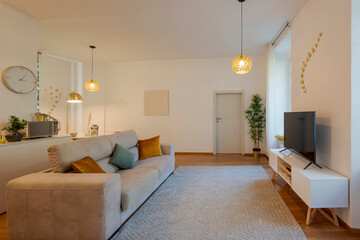 Front view modern living room furnished with sofa on the left and cabinet for tv and tv on the right