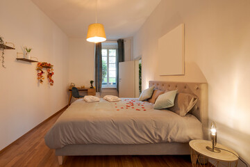 Intimate and romantic bedroom with large bed, paquet floor