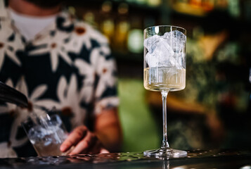 bartender making cocktail glass in bar