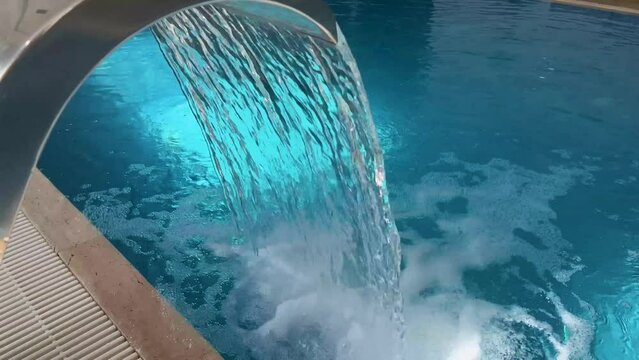 Empty Swimming pool with waterfall jet and jacuzzi in action