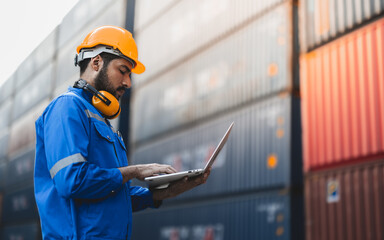 Container operator holding a laptop while working in container yards.